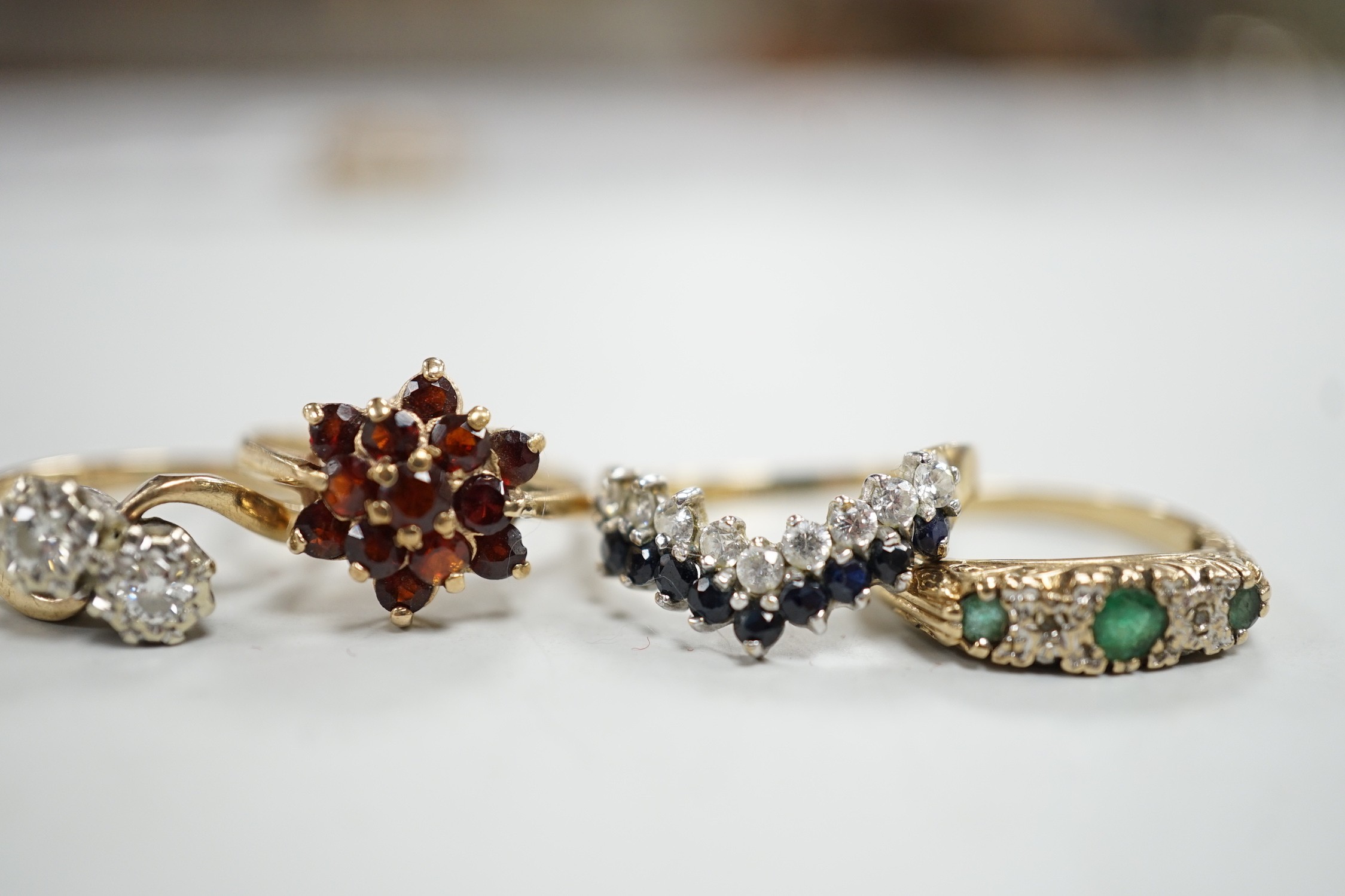 Four assorted modern 9ct gold and gem set rings, including a two stone diamond crossover, size K/L, gross 8.5 grams.
